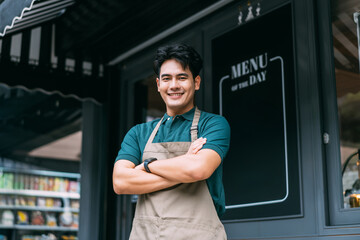 Young adult Asian business man crossing her arms in front of cafe restaurant while smiling. Happy...