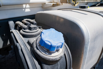Filler neck of the fuel tank closed with a blue plastic cap