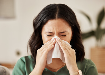 Blowing nose, tissue and woman in a living room with flu, cold and hay fever, crisis or viral...