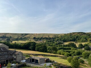 Evening view, across Lancashire countryside, with stone buildings, fields and trees near, Ainsley Lane, Marsden, UK
