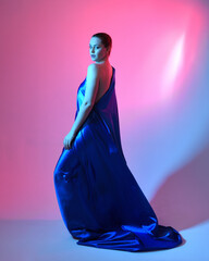 Full length portrait of beautiful female model wearing elegant flowing toga gown of blue silk...
