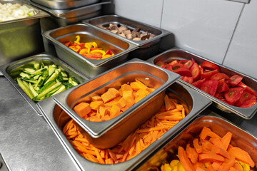 Stainless steel food trays on counter in professional kitchen