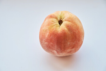 Close-up of a peach on a white background. View from above