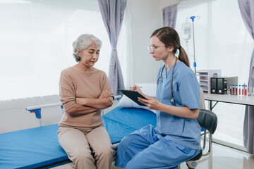 Obraz premium Portrait of beautiful doctor sharing data from digital tablet with elderly patient