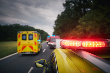 Ambulance cars and fire department vehicles on road. Themes rescue, urgency and health care.. - obrazy, fototapety, plakaty
