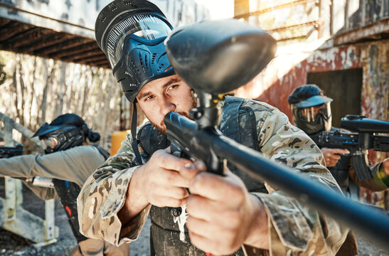 Paintball team, gun and man aim, focus or shooting at target, competition or battlefield conflict, fight or mission. Military group, hobby game or male shooter point weapon in war, training or battle