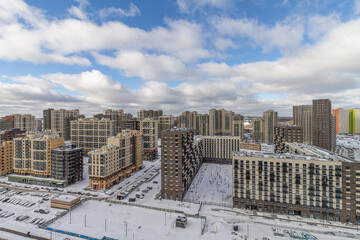 View of the city of Moscow, Moscow City from a bird's eye view. Top view in winter with snow, blue sky with clouds. New area, building high. Urban landscape with a courtyard.