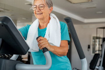 Obraz premium Senior fit woman doing exercises in gym to stay healthy. Sport, gym, wellbeing concept