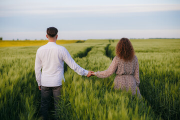 Couple in love on green field of wheat