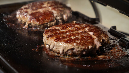Roasting juicy patties for burgers. Cooking at home, kitchen appliance, healthy nutrition, hamburger ingredients.