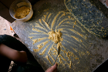 Preparing Peruvian yellow chili sauce with a fulling mill in the city of Cusco in Peru.