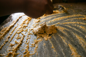 Preparing Peruvian yellow chili sauce with a fulling mill in the city of Cusco in Peru.