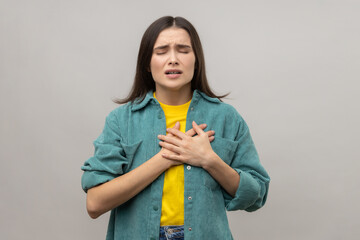 Portrait of sick woman suffering from pain in chest, grimacing with closed eyes, risk of heart...