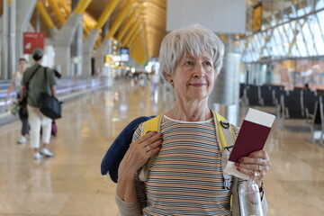 Seventy yeears old woman walking around  an airport terminal 