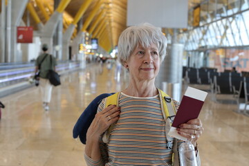 A senior woman in her sixties is in a transportation terminal
