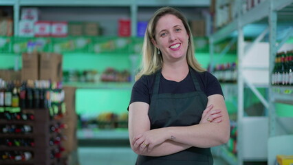 Joyful Expression of Female Supermarket Employee with Arms Crossed at Aisle, Happy Woman Staff Wearing Apron in Grocery Store
