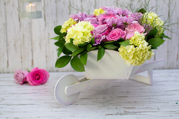 Obraz na płótnie Canvas Wheelbarrow Bouquet with Roses and Hydrangeas 
