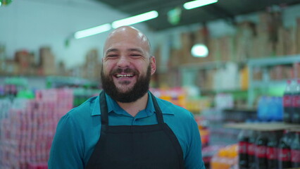 Portrait of Grocery Store male employee smiling at camera, close-up face of a happy staff wearing apron, job occupation concept