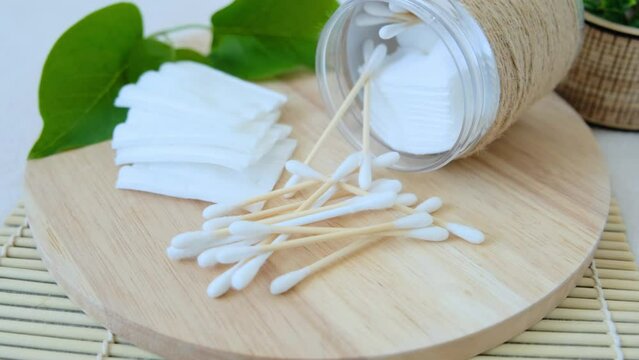 Close-up of cotton pads and cotton buds taken from a jar.