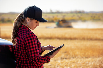 Young farm woman using advanced farming technologies during grain harvest, Alberta, Canada