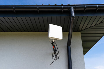 Fototapeta na wymiar Antenna amplifier for mobile internet at home, mounted on the facade of the house outside.