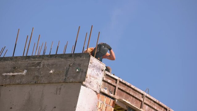 Welder with mask working on the construction site. Blue sky ibb the background.