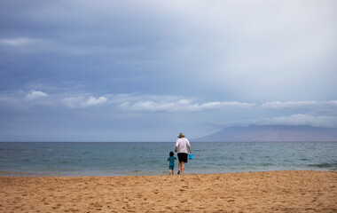 Grandmother and granddaughter walking along the Pacific shore at Maluaka Beach, Maui, Hawaii, USA