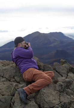Man taking pictures at Haleakala watching the sunrise over the Pacific, Maui, Hawaii, USA