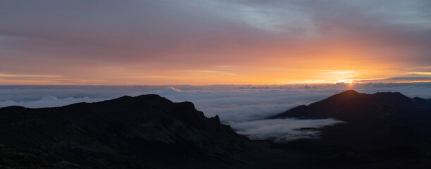 Fototapeta na wymiar Scenic view of Haleakala from mountain top overlooking the Pacific Ocean above the clouds at sunrise; Haleakala National Park, Maui, Hawaii, United States of America