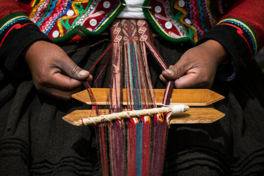 Quechuan women of Chinchero weave traditional clothes in traditional ways for sale; Cusco, Peru