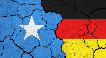 Flags of Somalia and Germany on cracked surface - politics, relationship concept