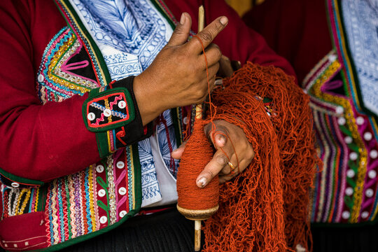 Quechuan women of Chinchero weave traditional clothes in traditional ways for sale; Cusco, Peru