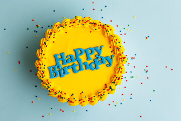 Yellow birthday cake with blue happy birthday greeting