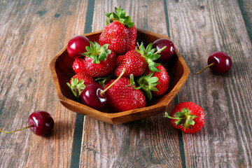 Fresh tasty strawberry and cherry on wooden background. Fresh organic berries macro. Fruit...