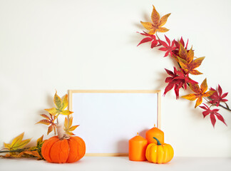 Mockup frame with pumpkins, candles and autumn leaves. Home interior with autumn fall decorations...