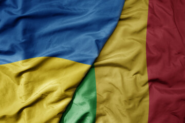 big waving national colorful flag of ukraine and national flag of mali .