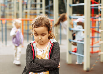 Upset lonely bullied little kid girl looking away feels abandoned abused, sad alone preschool child...