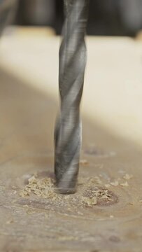 drill bit drilling wooden board