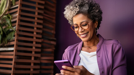 Modern senior latino woman shopping online with a digital tablet or smartphone; purple background with empty space for text 