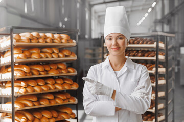 Portrait young woman baker in chef uniform, background modern bakery with copy space. Industrial...