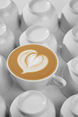 Bright photo for coffeeshop stories advertising. Logo heart on alone coffee latte or cappuccino in white cup background, top view