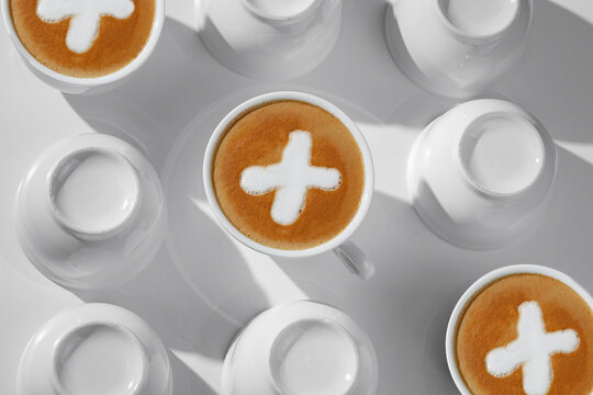 Bright photo for coffeeshop stories advertising. Logo play tic-tac-toe coffee latte or cappuccino in white cup background, top view