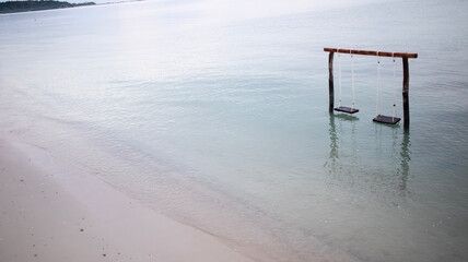 Wooden swings on the beach with views of the calm and beautiful sea water, the beach is perfect for a vacation - belitung Indonesia