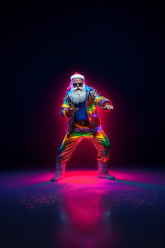 Trendy Santa Claus in fluorescent clothes illuminated by neon lights on a dark background. Concept of Christmas and New Year celebration and party, Luminous colors. Generative AI.