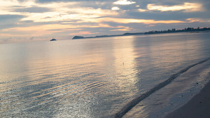 Fantastic close-up view of calm ocean water with orange sunrise. Tropical island beach views, exotic beaches.