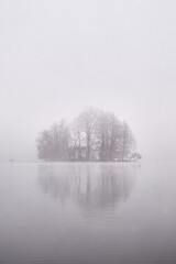 Island in the lake on a foggy morning