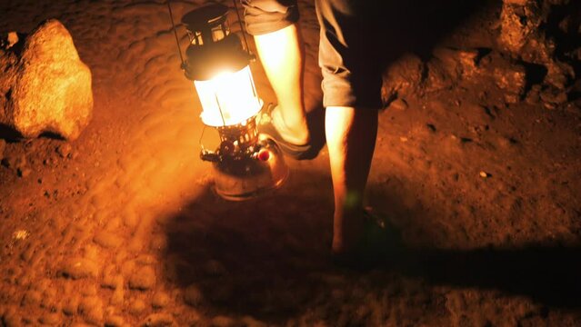 Tourist guide holding burning lantern and walking through Tham Lod cave - famous natural limestone cave system, Northern Thailand. High Quality 4K slowmotion travel nature exploring concept footage.