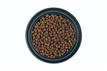 Round feeding bowl with  dog or cat kibble seen  directly above. Isolated on a white background.