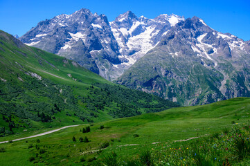 Mountains and alpine meadows views near Col du Lautaret, Massif des Ecrins, Hautes Alpes, France in...