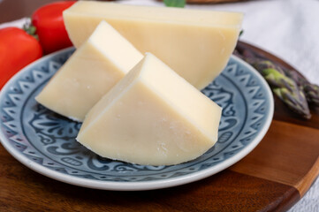 Italian cheese, Provolone dolce cow cheese from Cremona served with olive bread and tomatoes close up